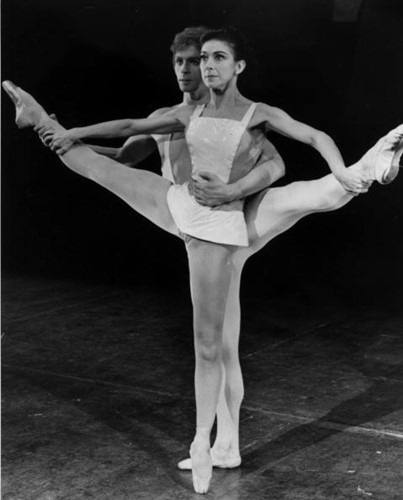 Two dancers each with a leg elevated