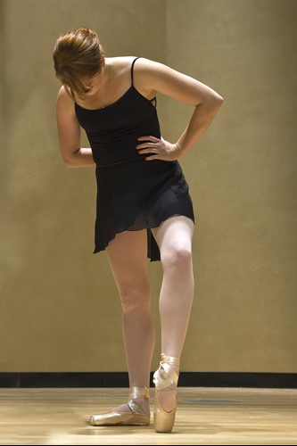 A ballet dancer looking at her feet